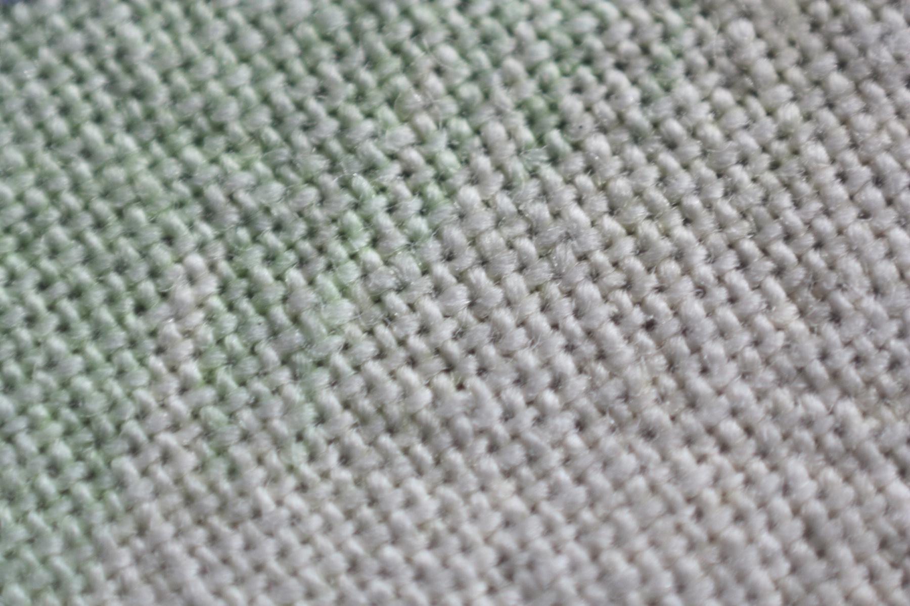 File:Simple-textile-magnified.jpg - a close up of a white and green colored knit fabric